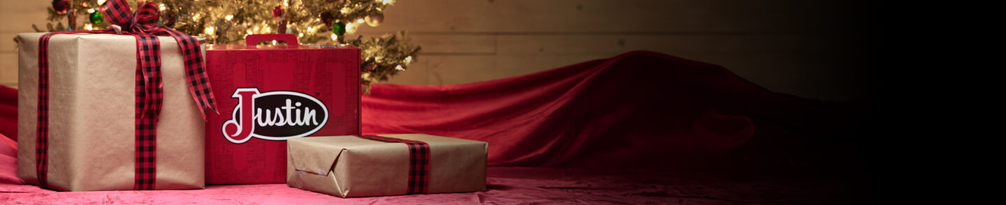 Justin boot box beneath a Christmas tree with other presents.